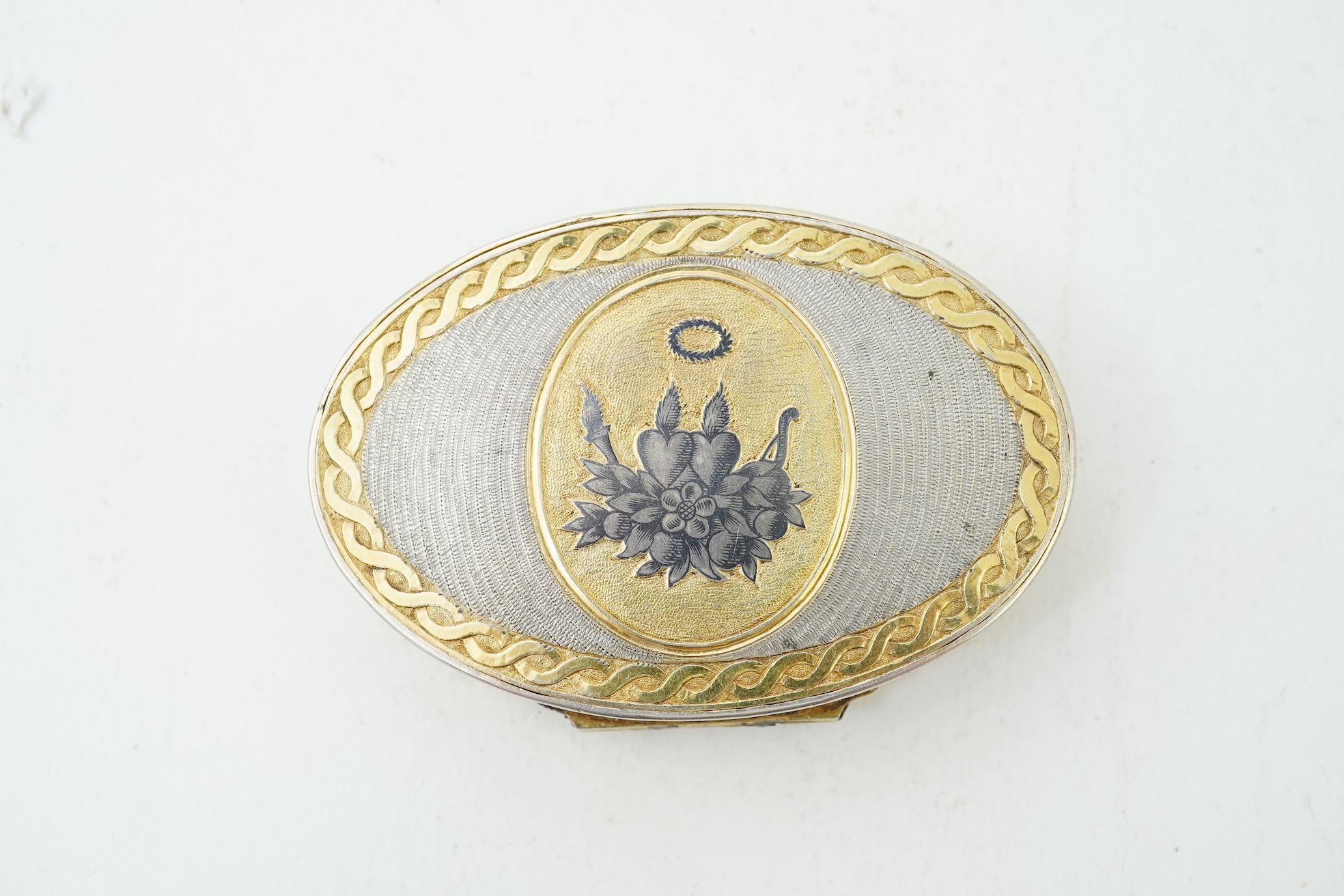 A 19th century Swiss? parcel gilt white metal oval snuff box with hinged cover